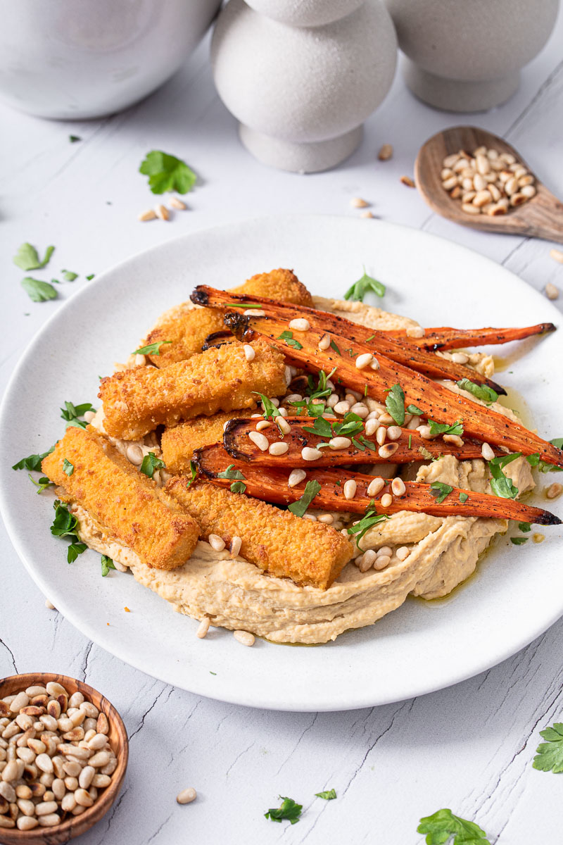 Fischstäbchen mit glasierten Möhren auf Hummus