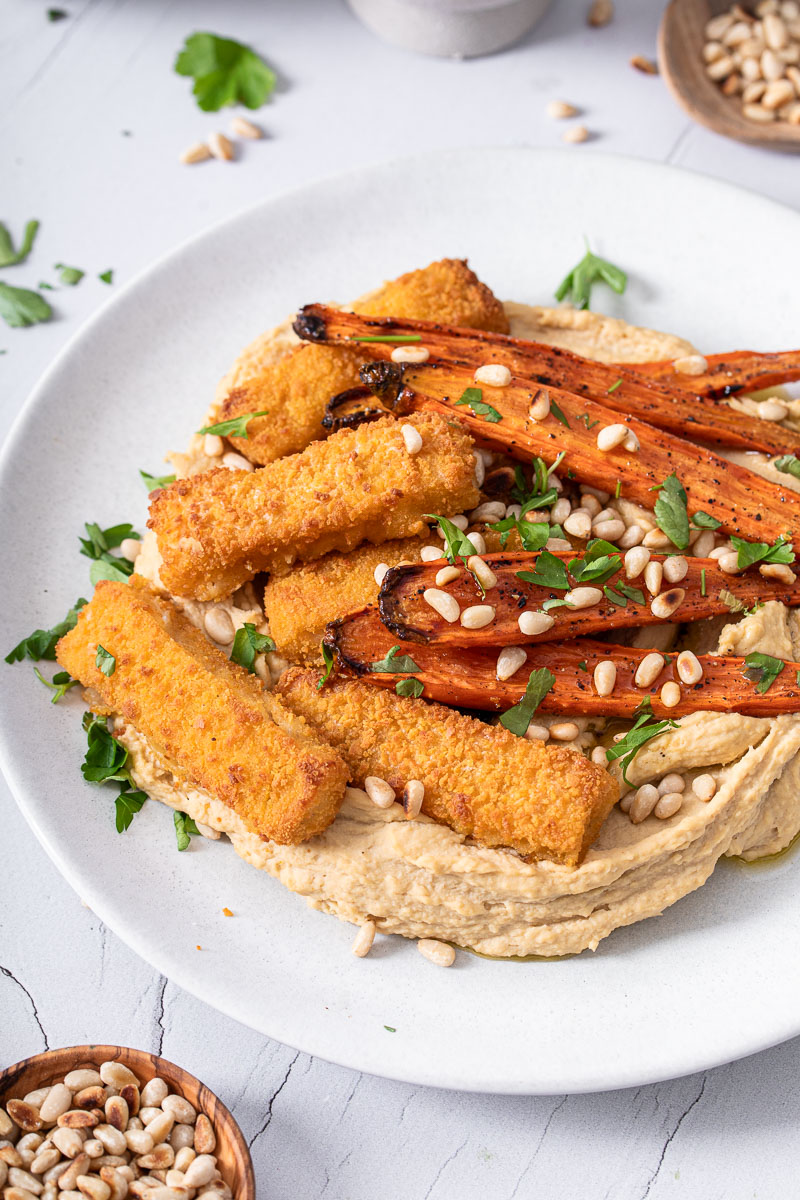 Fischstäbchen mit glasierten Möhren auf Hummus