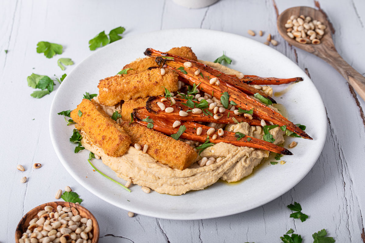 Fischstäbchen mit glasierten Möhren auf Hummus