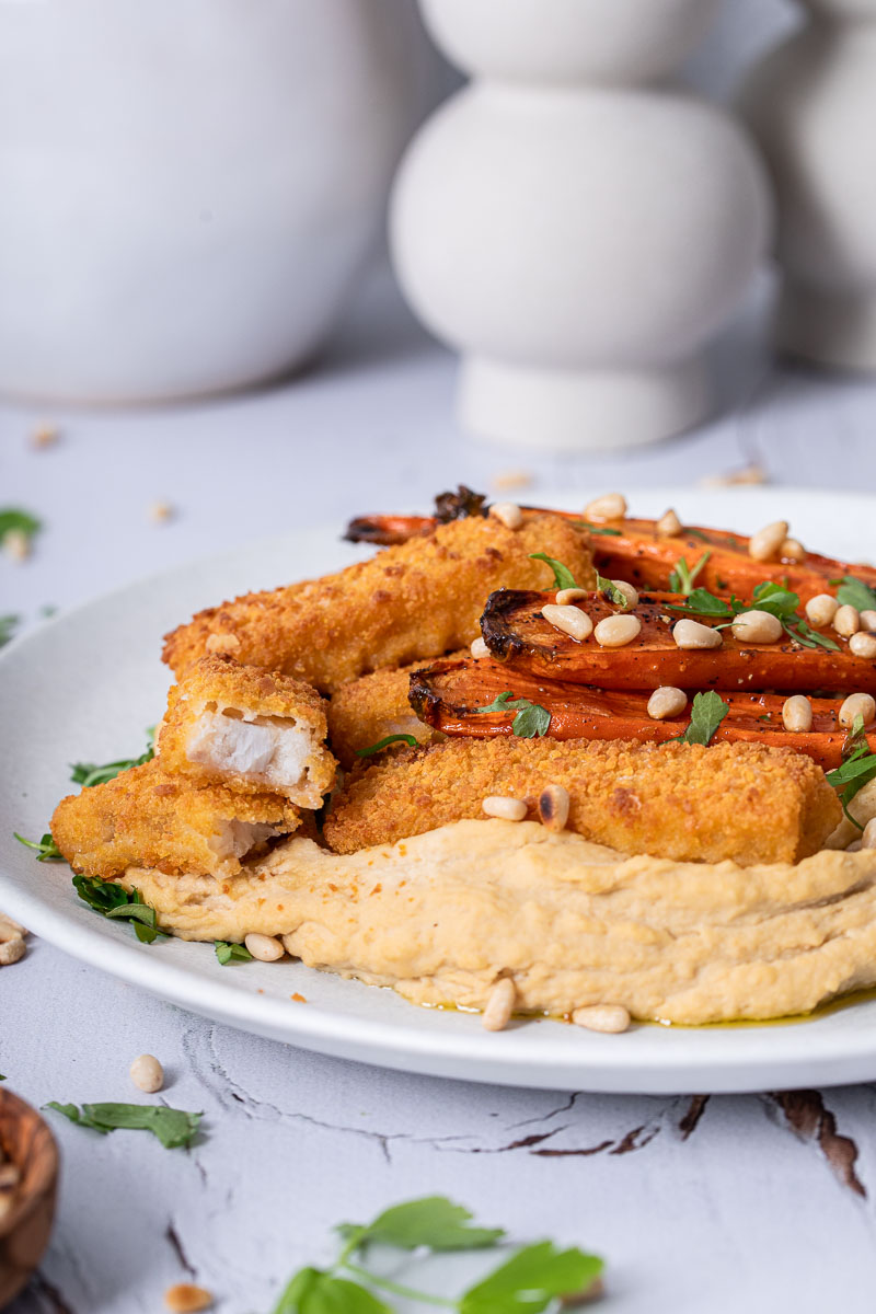 Fischstäbchen mit glasierten Möhren auf Hummus